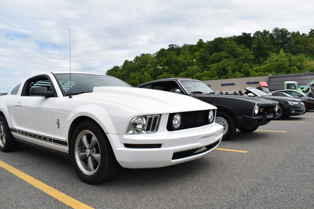 white mustang and ford maverick at cars and coffee bridgeport